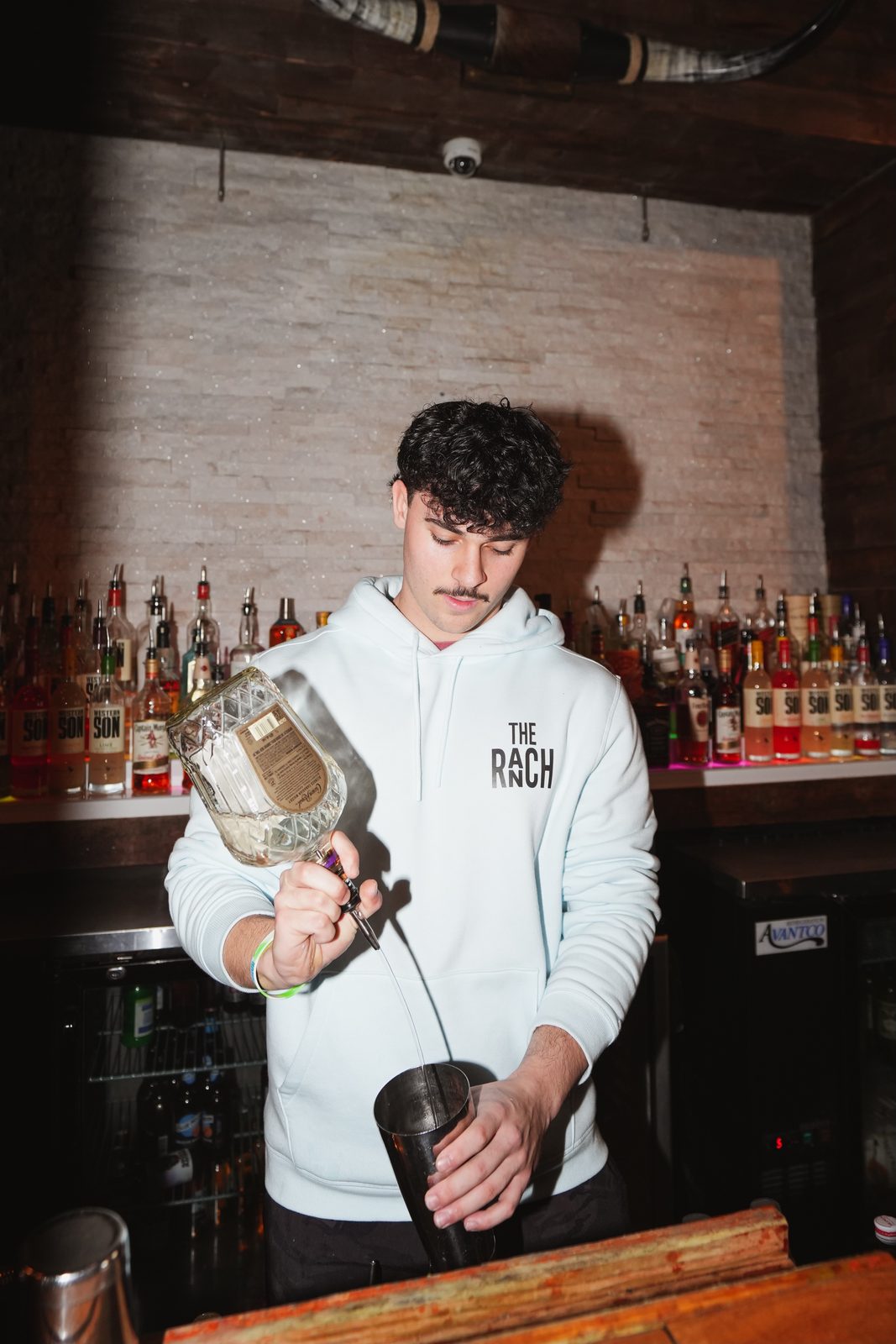 Bartender shaking a cocktail behind the bar at Whiskey Ranch