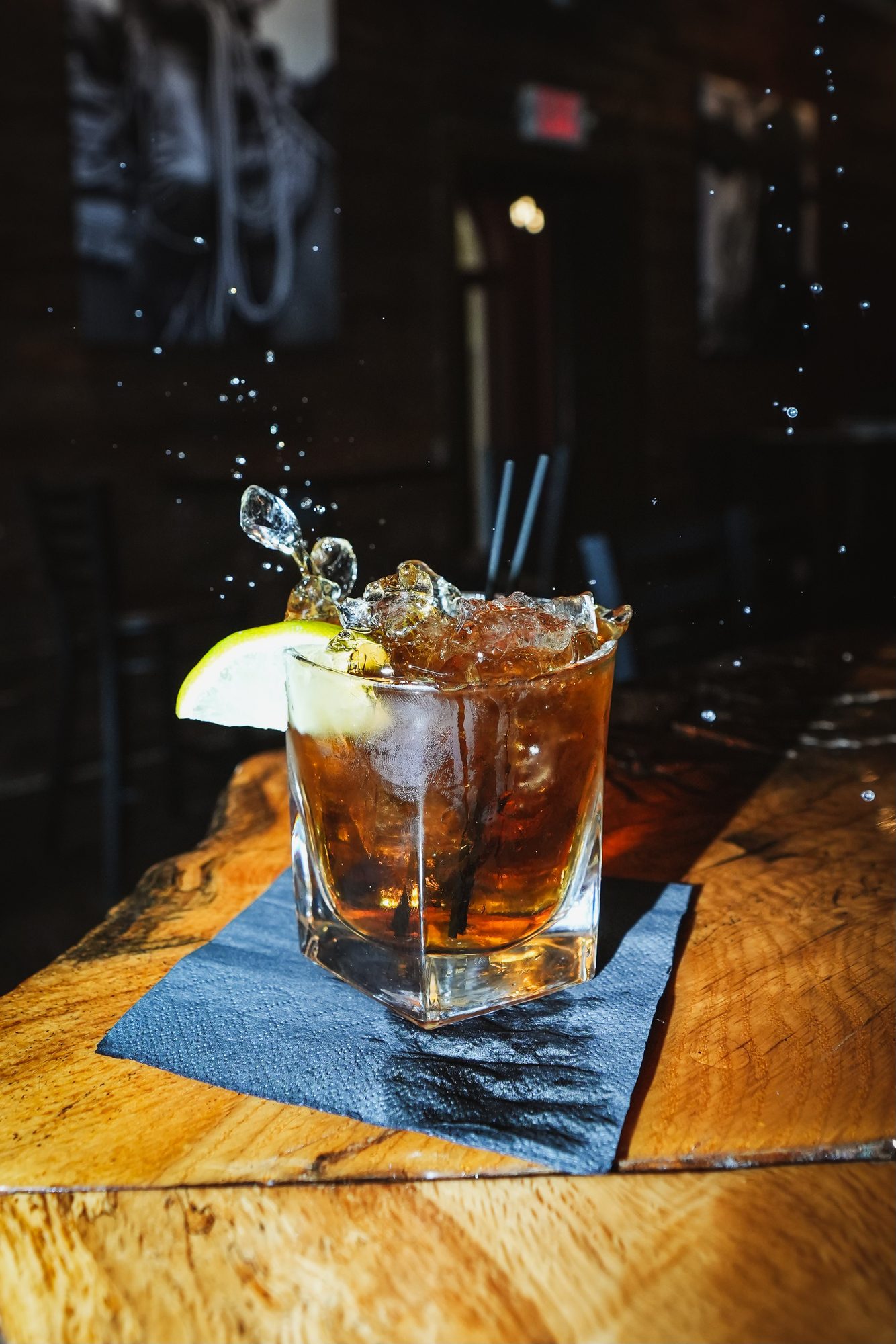 An old fashioned cocktail splashing on the bar at Whiskey Ranch