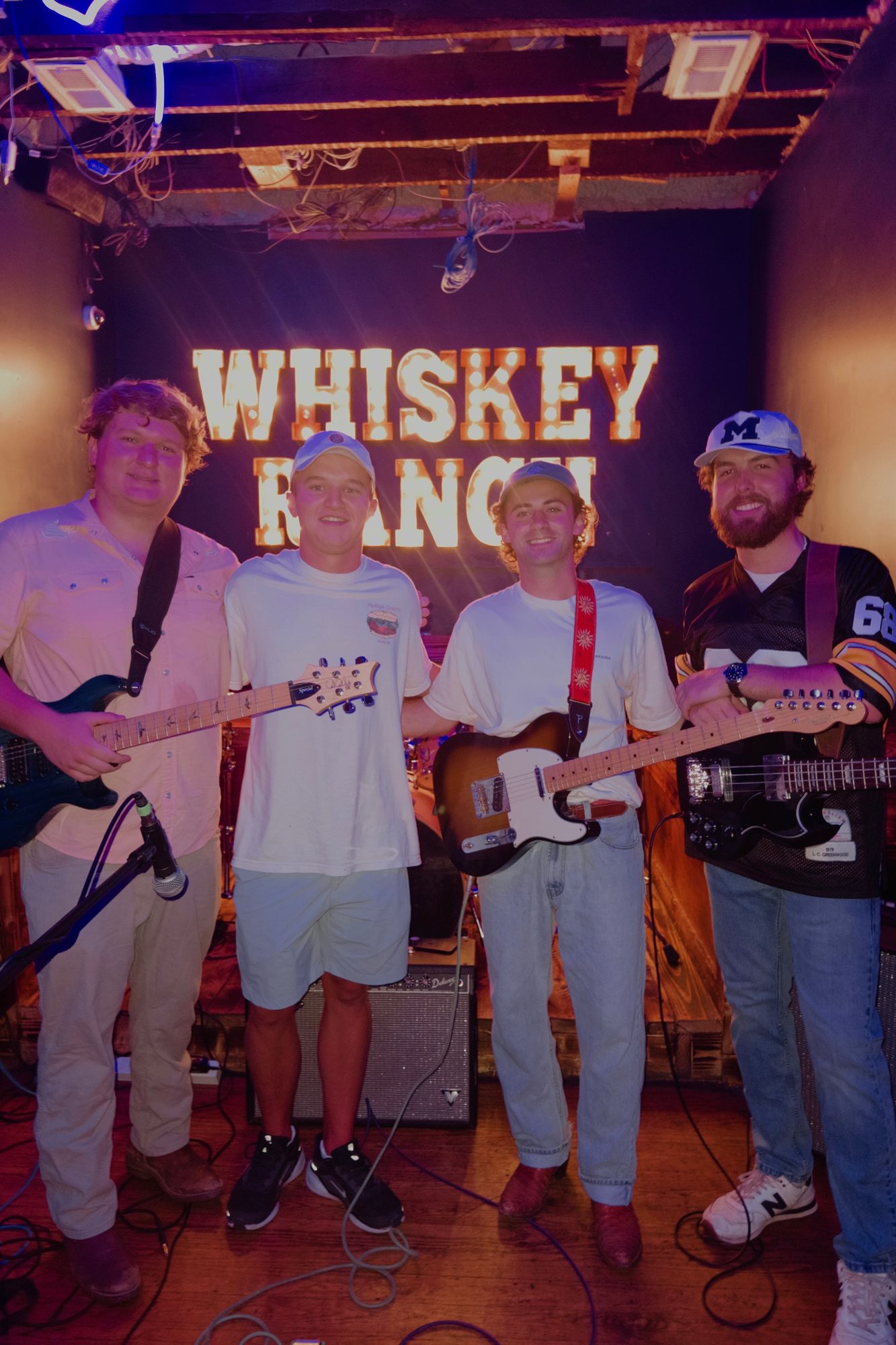 Live band performing on stage under the Whiskey Ranch sign